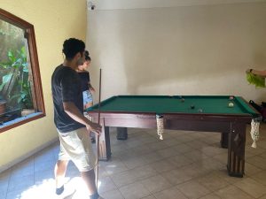 Kleber, jogando sinuca com a amiga Maria Eduarda.